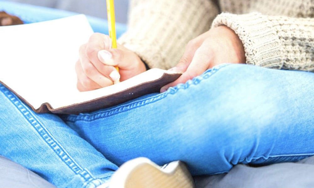 young lady writing in a journal