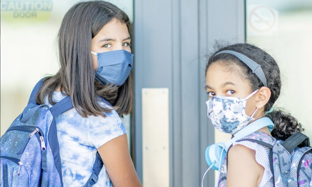 2 young girls wearing masks